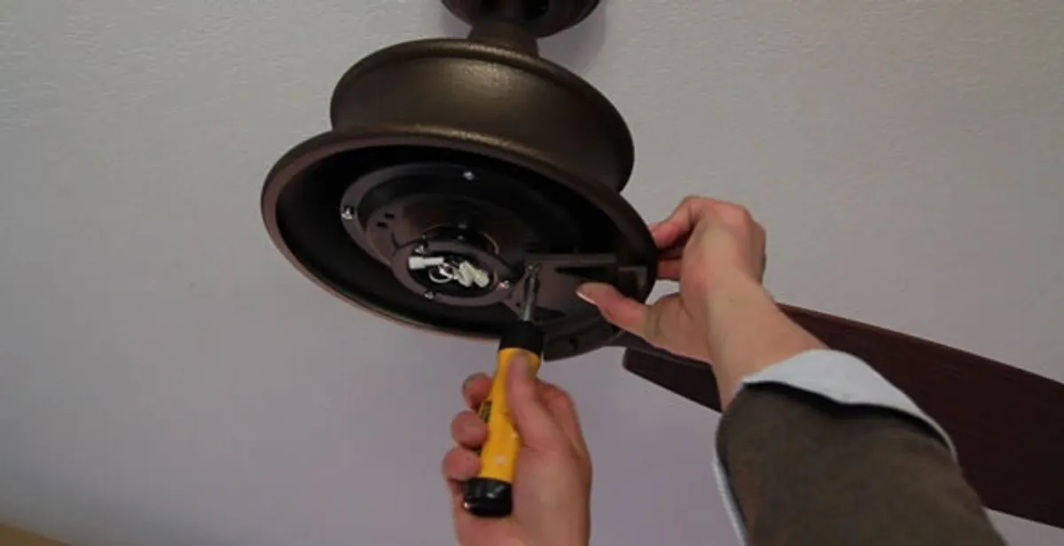 Electrician installing ceiling fan mounting bracket and fixture in Phoenix, AZ