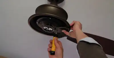 Electrician installing ceiling fan mounting bracket and fixture in Phoenix, AZ