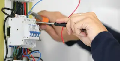 Electrician installing and adjusting circuit breakers in an electrical panel in Phoenix, AZ