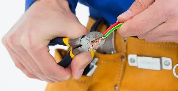 licensed electrician securing electrical wiring with professional tools during service work in Phoenix, AZ