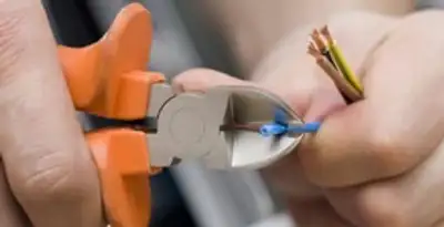 licensed electrician performing precise wire cutting and preparation during electrical service in Phoenix, AZ