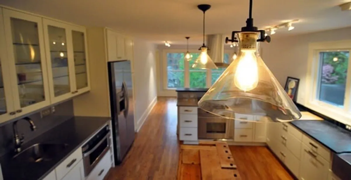 Residential electrician installing modern indoor light fixture in a home in Phoenix, AZ