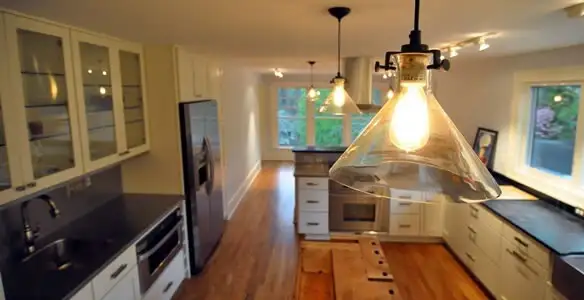 Residential electrician installing modern indoor light fixture in a home in Phoenix, AZ